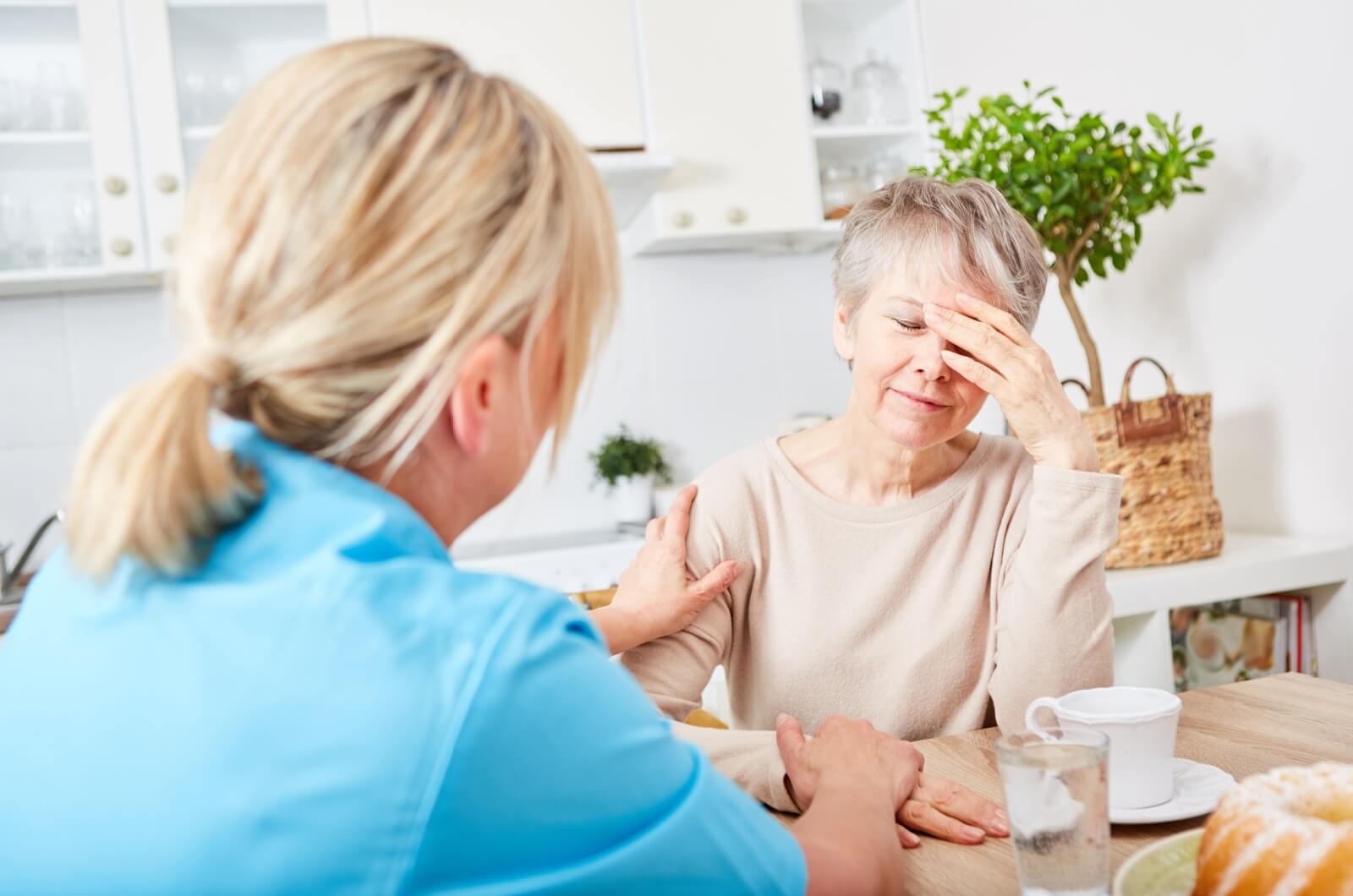 A caregiver comforting an older adult with dementia.